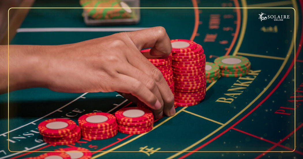 Baccarat Tips - A Hand Stacking A Group Of Poker Chips