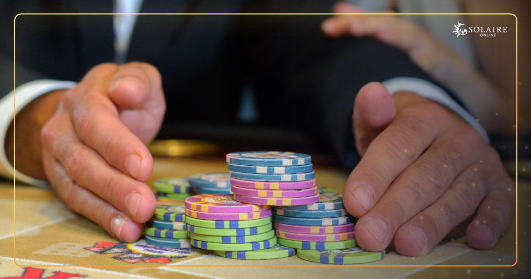 What Is Baccarat - A Hand Gathering Poker Chips On TableWhat Is Baccarat - A Hand Gathering Poker Chips On Table